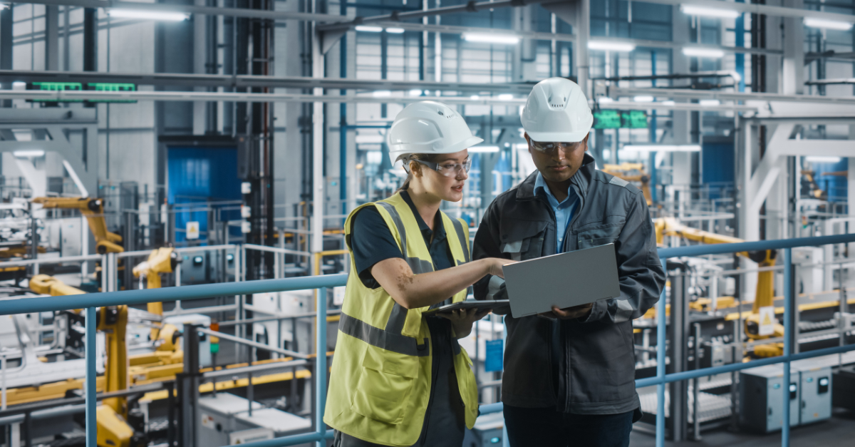 Woman and man in manufacturing look at data in laptop